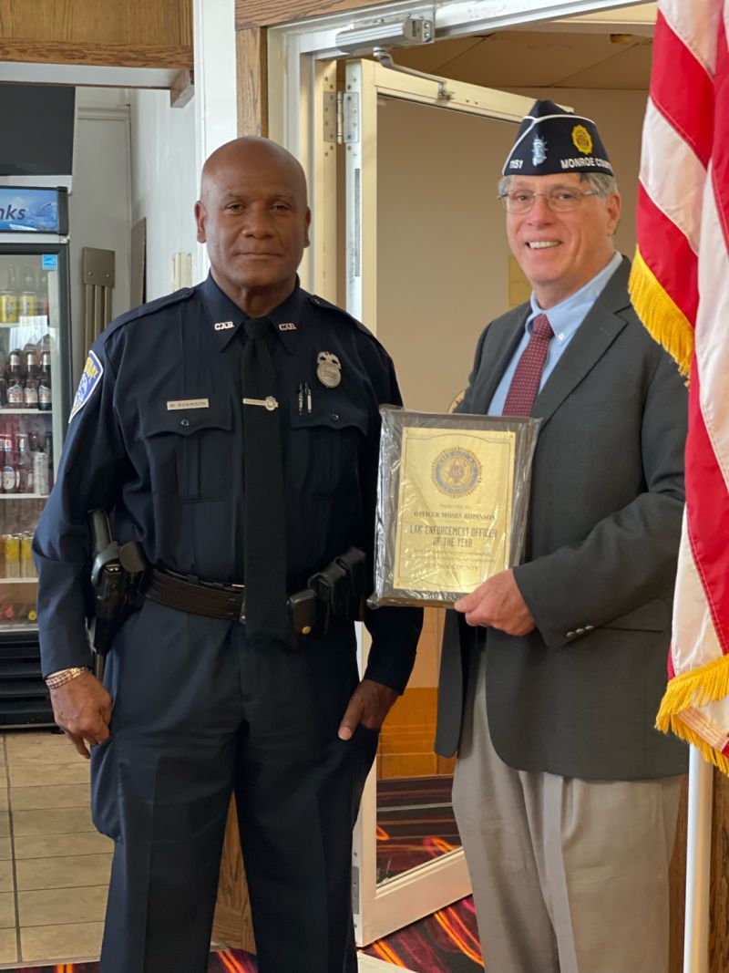 Moses Robinson in uniform receiving a Law Enforcement Officer of the Year plaque