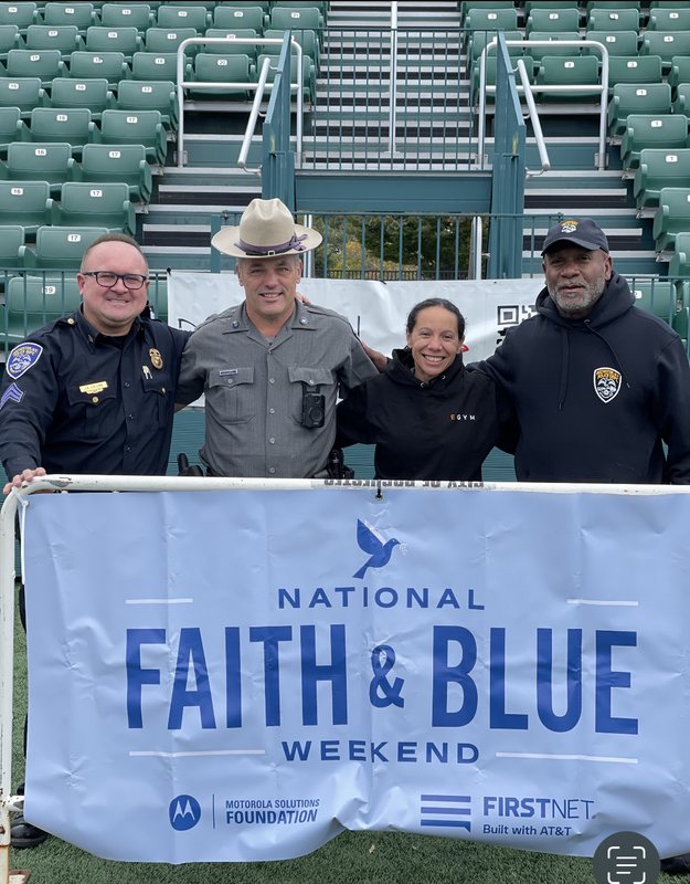 Officers and community members behind the National Faith and Blue Weekend banner