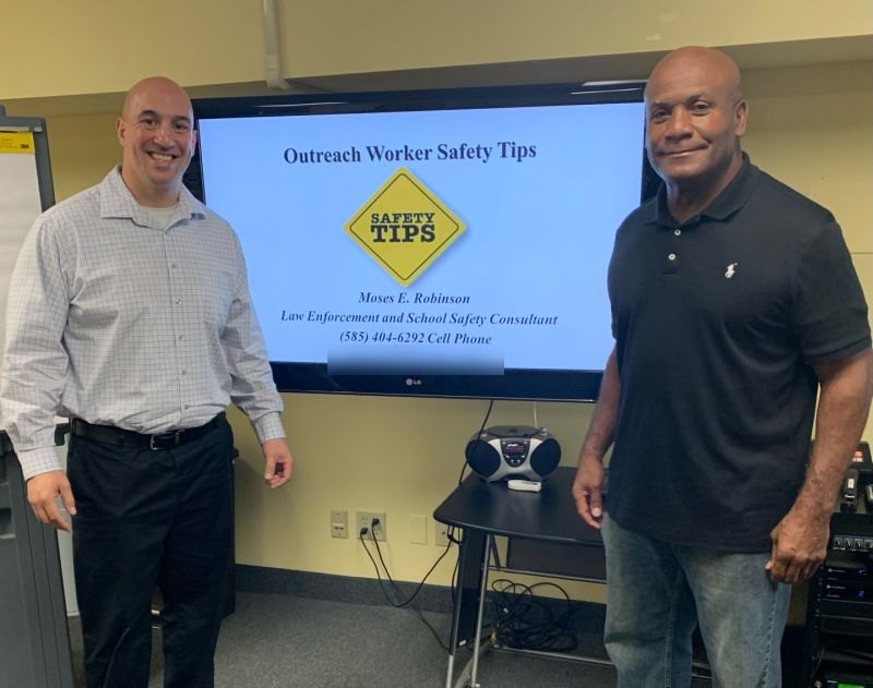 Moses Robinson beside his Outreach Worker Safety Tips presentation